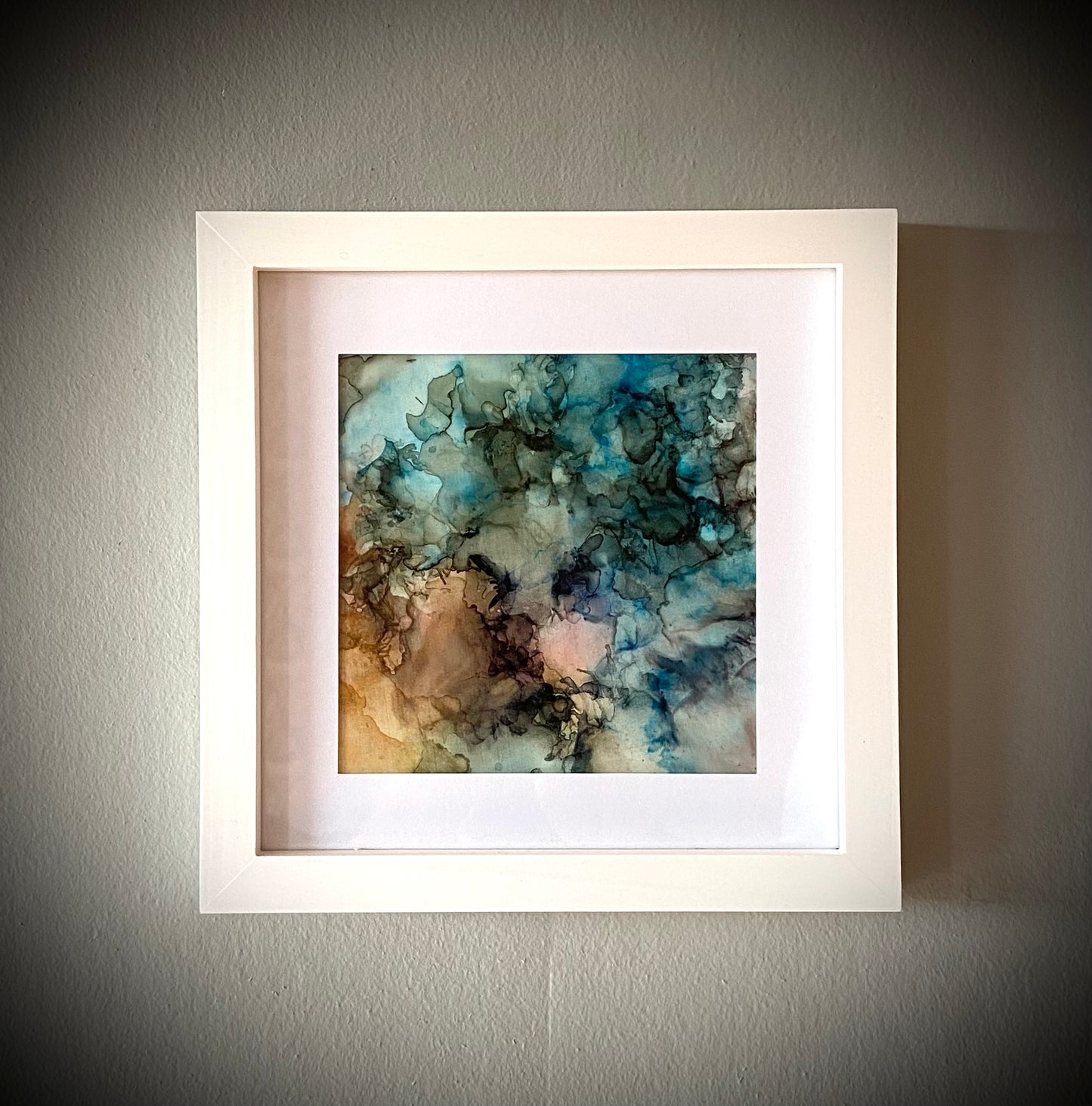 Tavla i alkoholbläck. Vit ram 22x22 cm. Målningen med passepartout 14x14 cm.